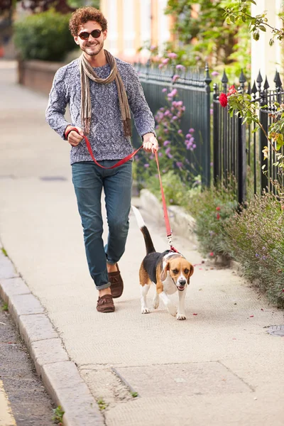 Чоловік бере собаку для прогулянки — стокове фото