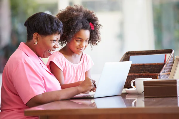 Flicka att hjälpa mormor med laptop — Stockfoto