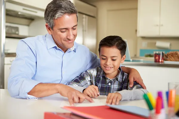 Pai hispânico ajudando filho com lição de casa — Fotografia de Stock