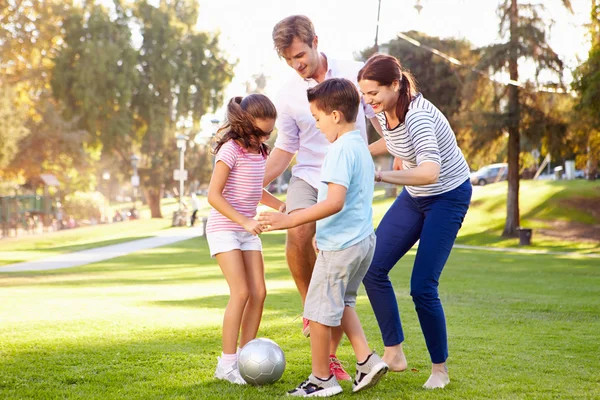 Familj spelar fotboll i parken — Stockfoto