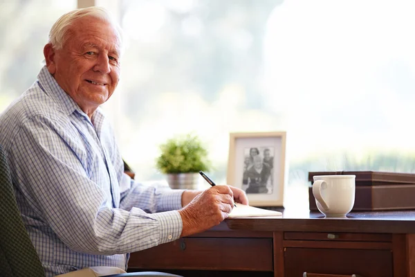 Hombre mayor escribiendo memorias en el libro — Foto de Stock