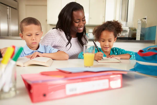 Moeder helpt kinderen met huiswerk — Stockfoto