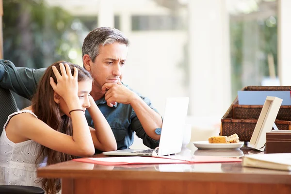 Padre ayudando a la hija mirando al ordenador portátil — Foto de Stock