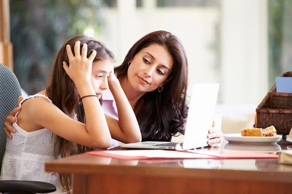 Madre ayudando a la hija mirando a la computadora portátil — Foto de Stock