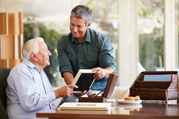 Senior Vater schaut sich Foto im Rahmen mit Sohn an — Stockfoto