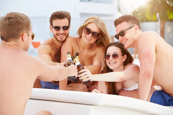 Jovens relaxando por piscina — Fotografia de Stock