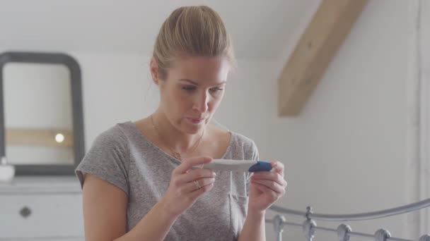 经家庭怀孕测试呈阳性的兴奋女性坐在床上 — 图库视频影像