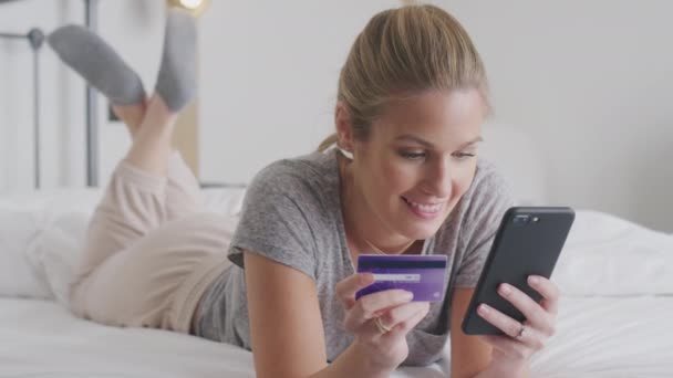 Kvinna Som Ligger Sängen Med Mobiltelefon Handla Online Med Kreditkort — Stockvideo