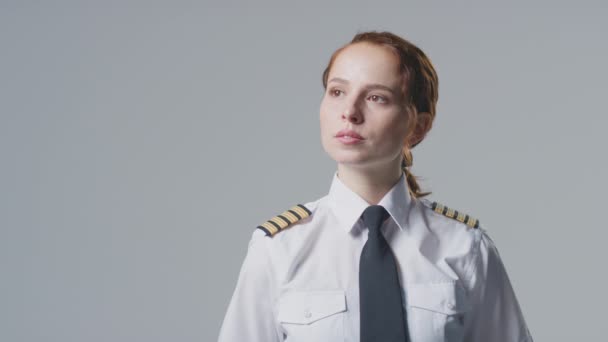 女性の航空会社パイロットや船長のスタジオ肖像画は プレーンな背景にカメラを探して — ストック動画