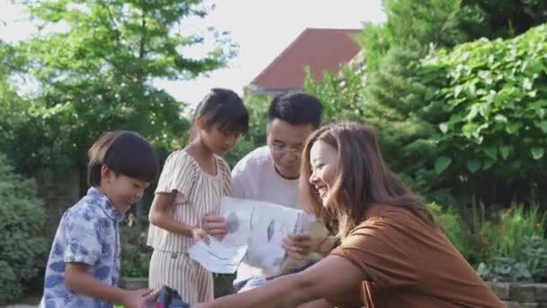 夏のキャンプ旅行のためにテントを張る自宅で庭で楽しいアジアの家族 — ストック動画
