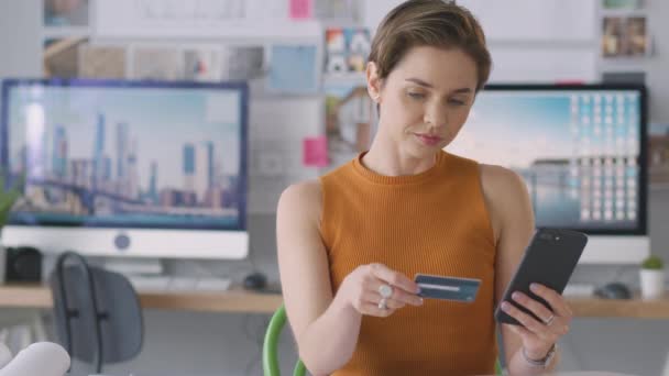 Ofisteki Kadın Mimar Cep Telefonunda Kredi Kartı Kullanarak Çevrimiçi Alım — Stok video