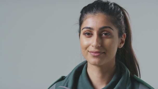 Close Studio Portræt Smilende Ung Kvindelig Paramediciner Mod Almindelig Baggrund – Stock-video