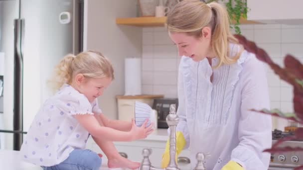 Madre Usando Guantes Goma Casa Cocina Con Hija Pequeña Divirtiéndose — Vídeos de Stock