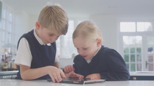 Two Children Wearing School Uniform Kitchen Playing Digital Tablet Counter — Stock Video