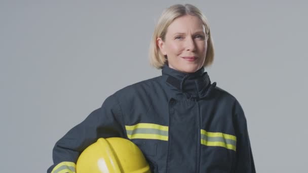 Estudio Retrato Sonrisa Madura Bombero Femenino Contra Fondo Llano — Vídeos de Stock