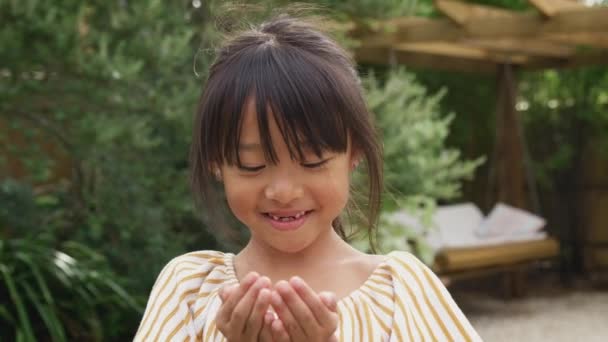 Portré Mosolygó Ázsiai Lány Hiányzó Első Fogak Szórakozás Fúj Toll — Stock videók