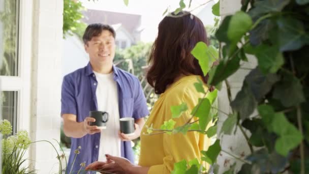 Reife Asiatin Pflanzt Holzgefäße Sommergarten Während Ehemann Ihr Heißgetränk Tasse — Stockvideo