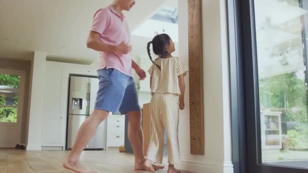亚洲父亲在家里测量女儿的墙面尺寸 而她却站在墙脚上 — 图库视频影像