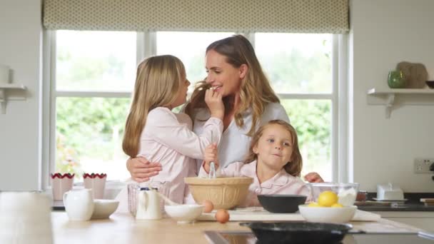 母と二人の娘は一緒に自宅で台所でパジャマ焼きを着ています — ストック動画