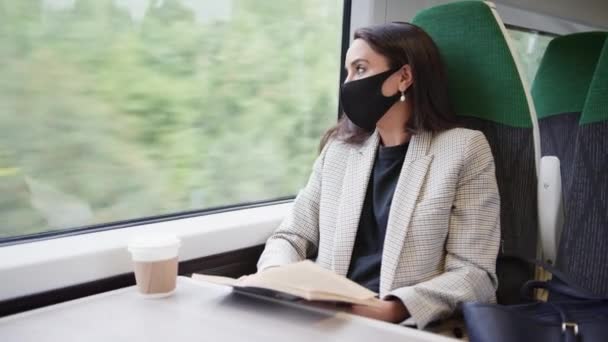 健康中にPpeフェイスマスクを身に着けている電車の中でリラックスして読書本のビジネスマンの女性流行 — ストック動画