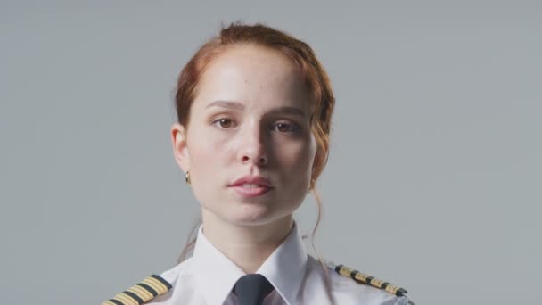 プレーンな背景を持つ深刻な女性航空会社パイロットや船船長のスタジオ肖像 — ストック動画