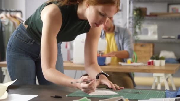 Female Fashion Designer Drawing Design Foreground Male Colleague Works Sewing — Stock Video