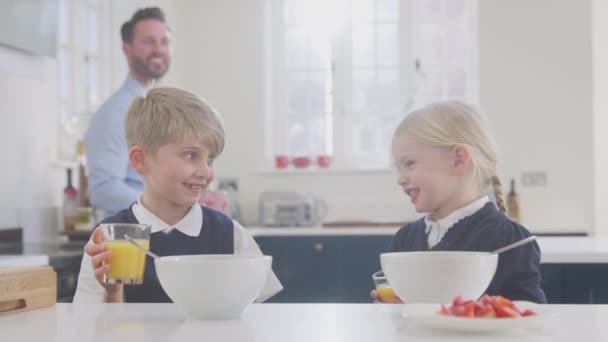Двоє Дітей Шкільній Формі Кухні Їдять Сніданок Коли Батько Готується — стокове відео