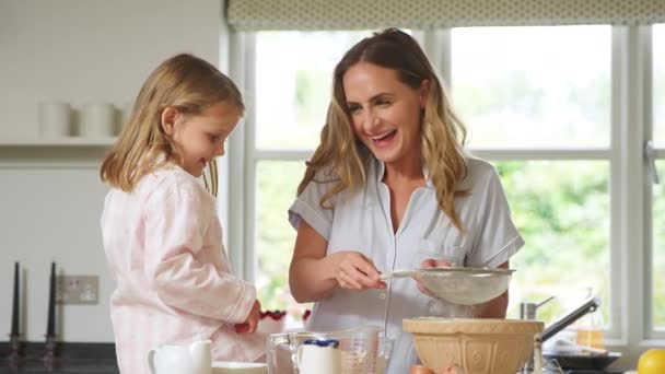 妈妈和女儿穿着睡衣在家里的厨房里一起烘焙和做煎饼 — 图库视频影像