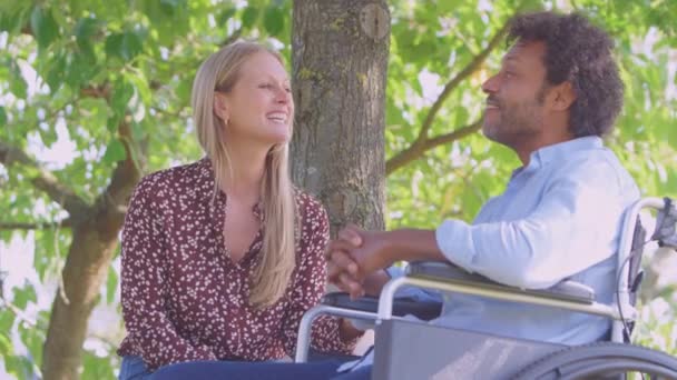 Uśmiechnięta Dojrzała Para Mężczyzną Siedzącym Wózku Inwalidzkim Rozmawiającym Razem Parku — Wideo stockowe
