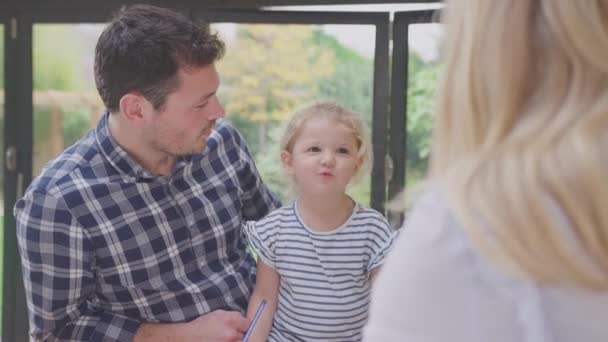 Föräldrar Hemma Vid Köksbänken Hjälper Unga Dotter Att Rita Bild — Stockvideo