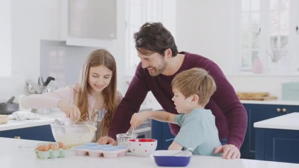 Padre Con Dos Hijos Cocina Casa Divirtiéndose Horneando Pasteles Juntos — Vídeos de Stock