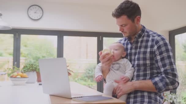 Padre Che Lavora Usando Computer Portatile Casa Mentre Alimenta Bambino — Video Stock