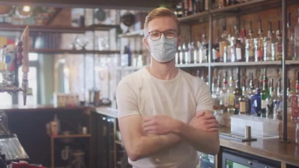 健康中に顔マスクを着用する男性バーワーカーの肖像 パンデミックカウンターの後ろに立つ — ストック動画