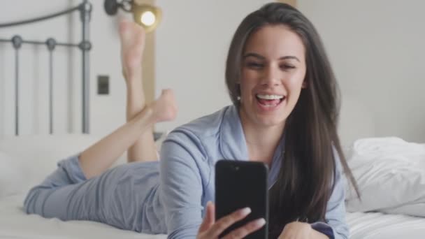 Perempuan Dengan Ponsel Mengenakan Pyjamas Memiliki Video Chat Lying Bed — Stok Video