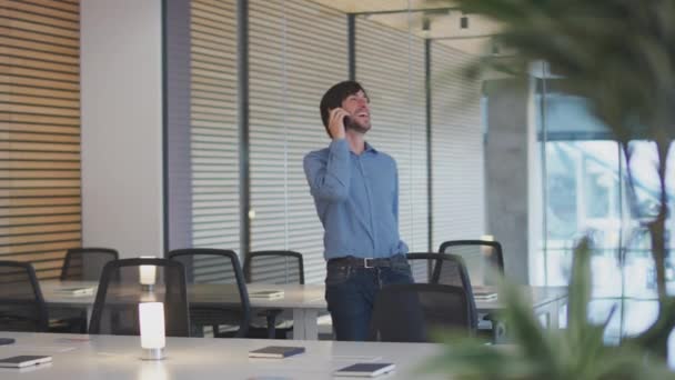 現代のオープンプランオフィスを歩く電話でビジネスマン — ストック動画