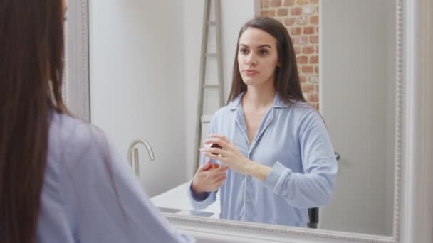 Femme Portant Pyjama Maison Dans Salle Bain Moderne Utilisant Hydratant — Video