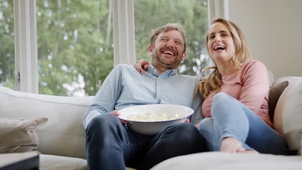 Ζευγάρι Ραντεβού Κάθεται Στον Καναπέ Στο Σπίτι Γελώντας Και Βλέποντας — Αρχείο Βίντεο