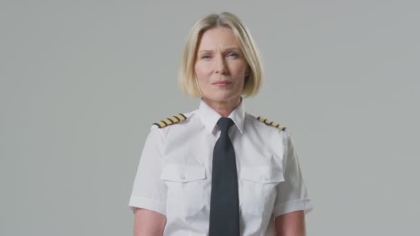 プレーンな背景を持つ深刻な熟女航空機パイロットや船船長のスタジオ肖像 — ストック動画