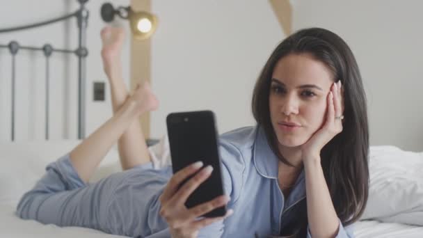 Perempuan Memakai Pyjamas Posing Taking Selfies Mobile Phone Lying Bed — Stok Video