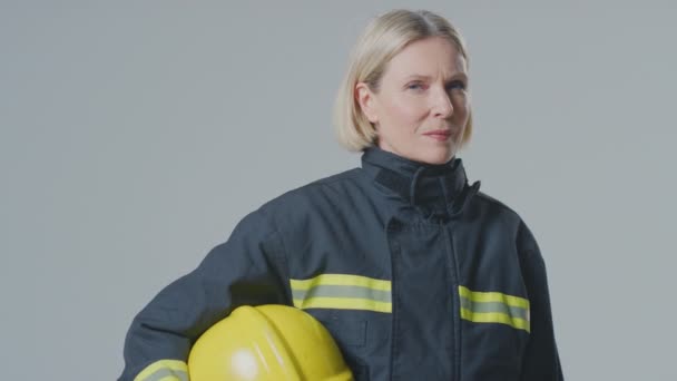 Studio Πορτρέτο Της Σοβαρής Ώριμη Γυναίκα Πυροσβέστης Έναντι Απλό Φόντο — Αρχείο Βίντεο