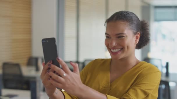 Młoda Bizneswoman Wideo Czat Telefon Komórkowy Połączenie Stojące Nowoczesnym Biurze — Wideo stockowe