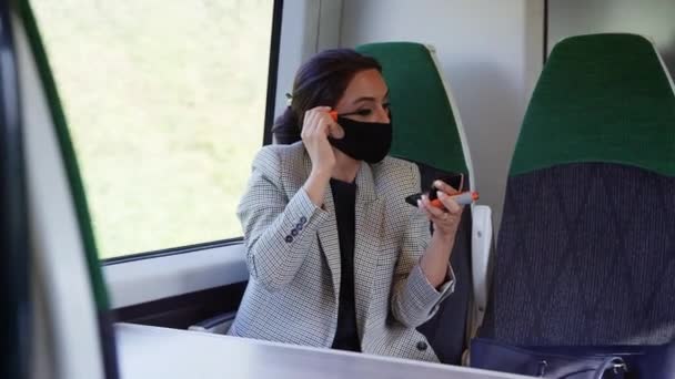 健康パンダ症の間にPpeフェイスマスクを身に着けている間にメイクを入れて電車の中でビジネスマン女性 — ストック動画