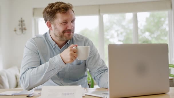 Χαμογελώντας Άνθρωπος Φορητό Υπολογιστή Κάθεται Στο Τραπέζι Στο Σπίτι Επανεξέταση — Αρχείο Βίντεο