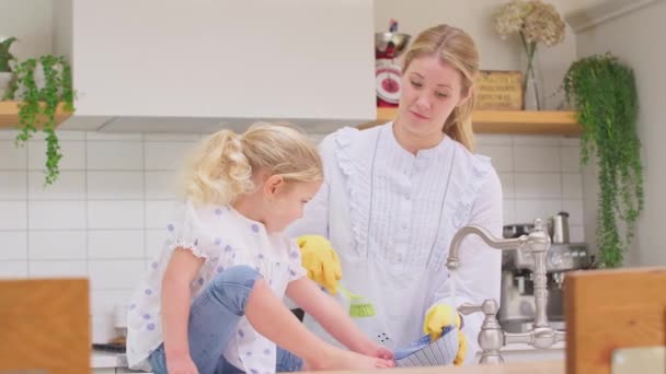 Madre Usando Guantes Goma Casa Cocina Con Hija Pequeña Divirtiéndose — Vídeo de stock