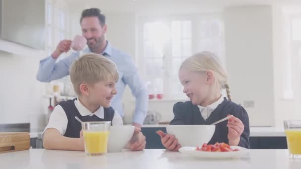 Δύο Παιδιά Φορώντας Σχολική Στολή Στην Κουζίνα Τρώγοντας Πρωινό Καθώς — Αρχείο Βίντεο