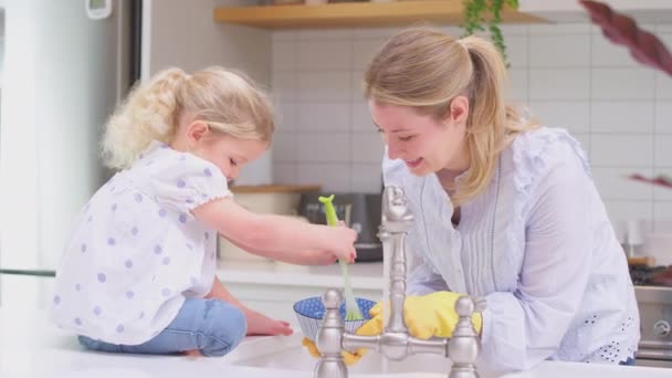 Madre Usando Guantes Goma Casa Cocina Con Hija Pequeña Divirtiéndose — Vídeos de Stock