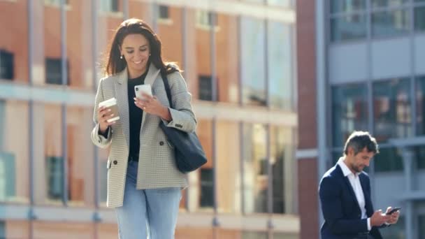 Affärskvinna Med Hämtmat Kaffe Promenader Till Kontoret Efter Anvisningar Mobiltelefon — Stockvideo