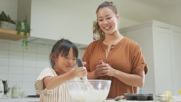 아시아 어머니와 부엌에서 케이크 만들기 재료를 혼합하는 — 비디오