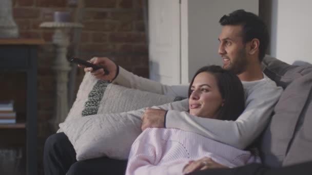 Pasangan Berbohong Dan Bersantai Pada Lounge Sofa Rumah Dan Menonton — Stok Video