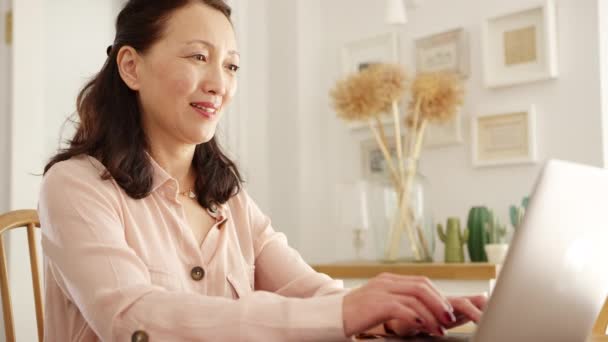 Gammal Asiatisk Kvinna Sitter Vid Bordet Hemma Med Laptop För — Stockvideo